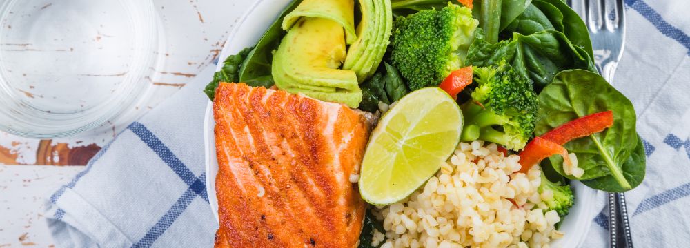 A balanced meal of salmon, whole grains, greens, broccoli and avocado illustrate various macronutrients in the post bariatric surgery diet 