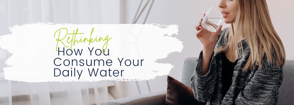 Woman sitting down drinking a glass of water